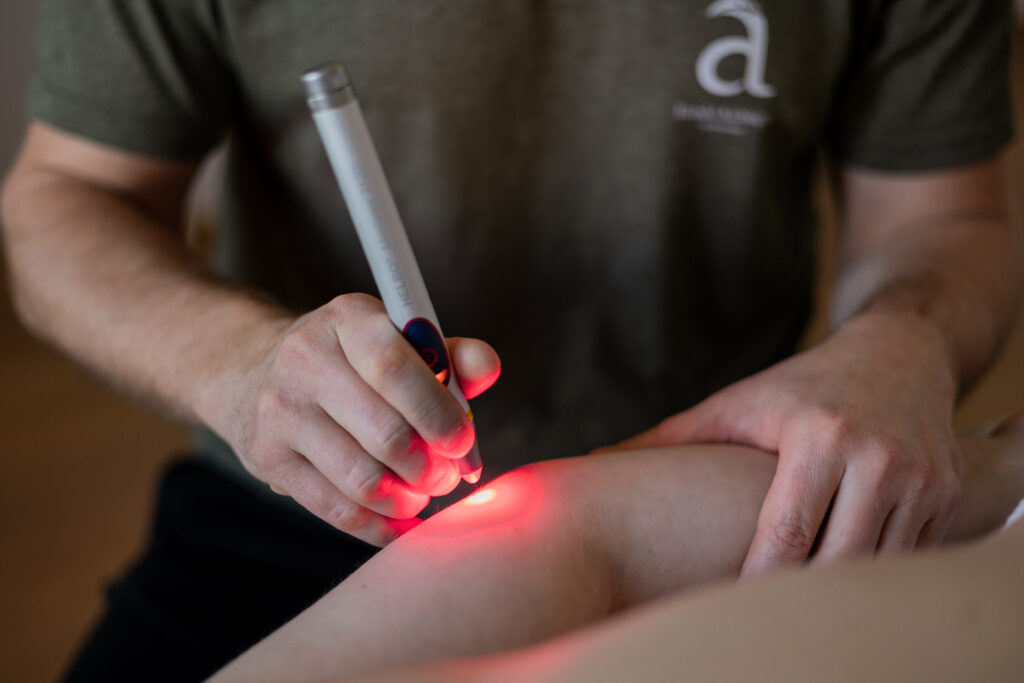 Laser mit rotem Licht wird auf Knie gerichtet